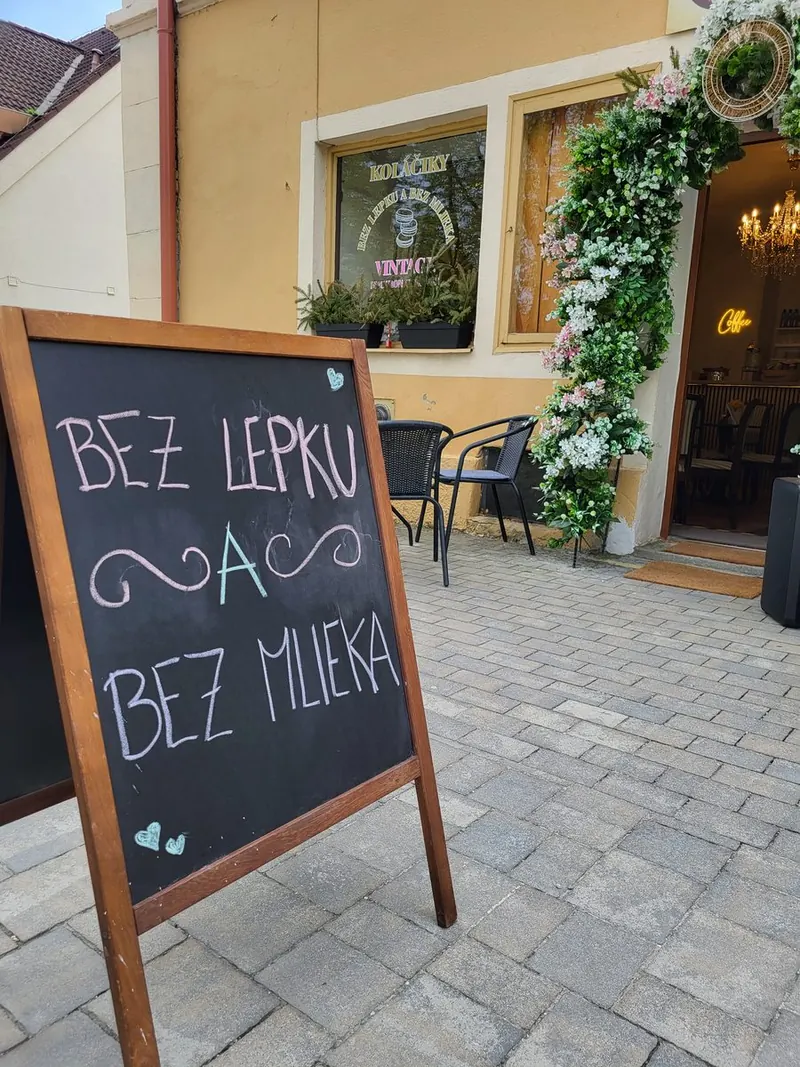 Terasa pred kaviarňou s tabuľou a otvorenými dverami