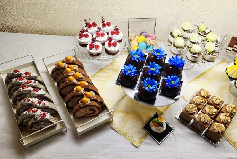 Prehľad candy baru s roládami, malinovými tortičkami a makrónkami