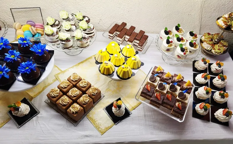 Celkový pohľad na svadobný candy bar s minidezertmi a makrónkami