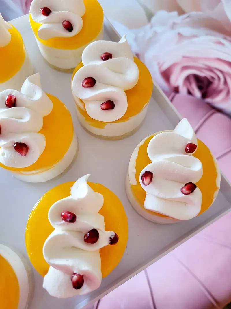 Mangové mini cheesecakes so šľahačkou a zrniečkami granátového jablka