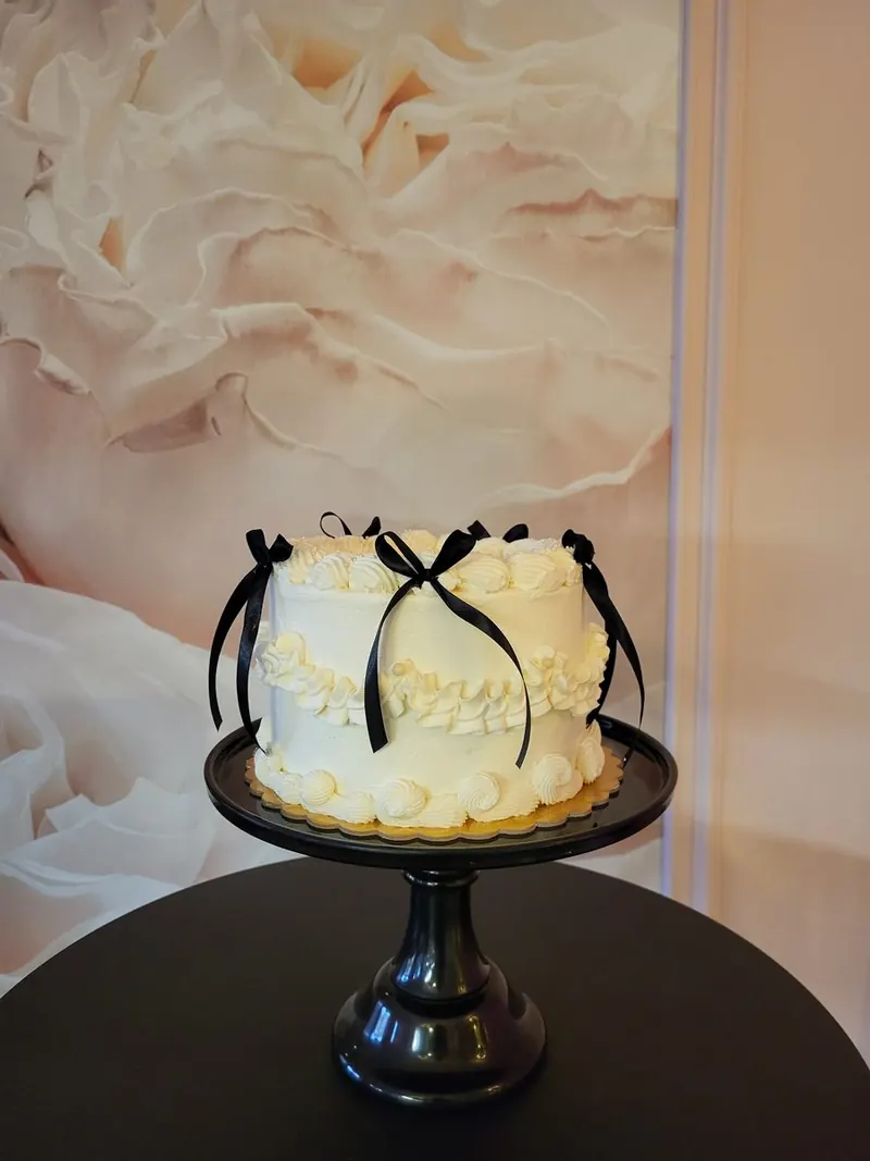 Biela vintage torta s čiernymi stužkami na čiernom stojane